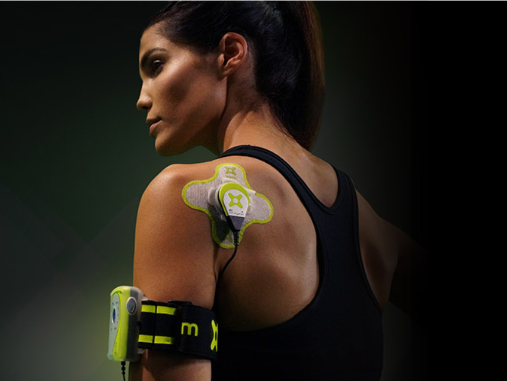 Woman wearing electronic device on arm and shoulder